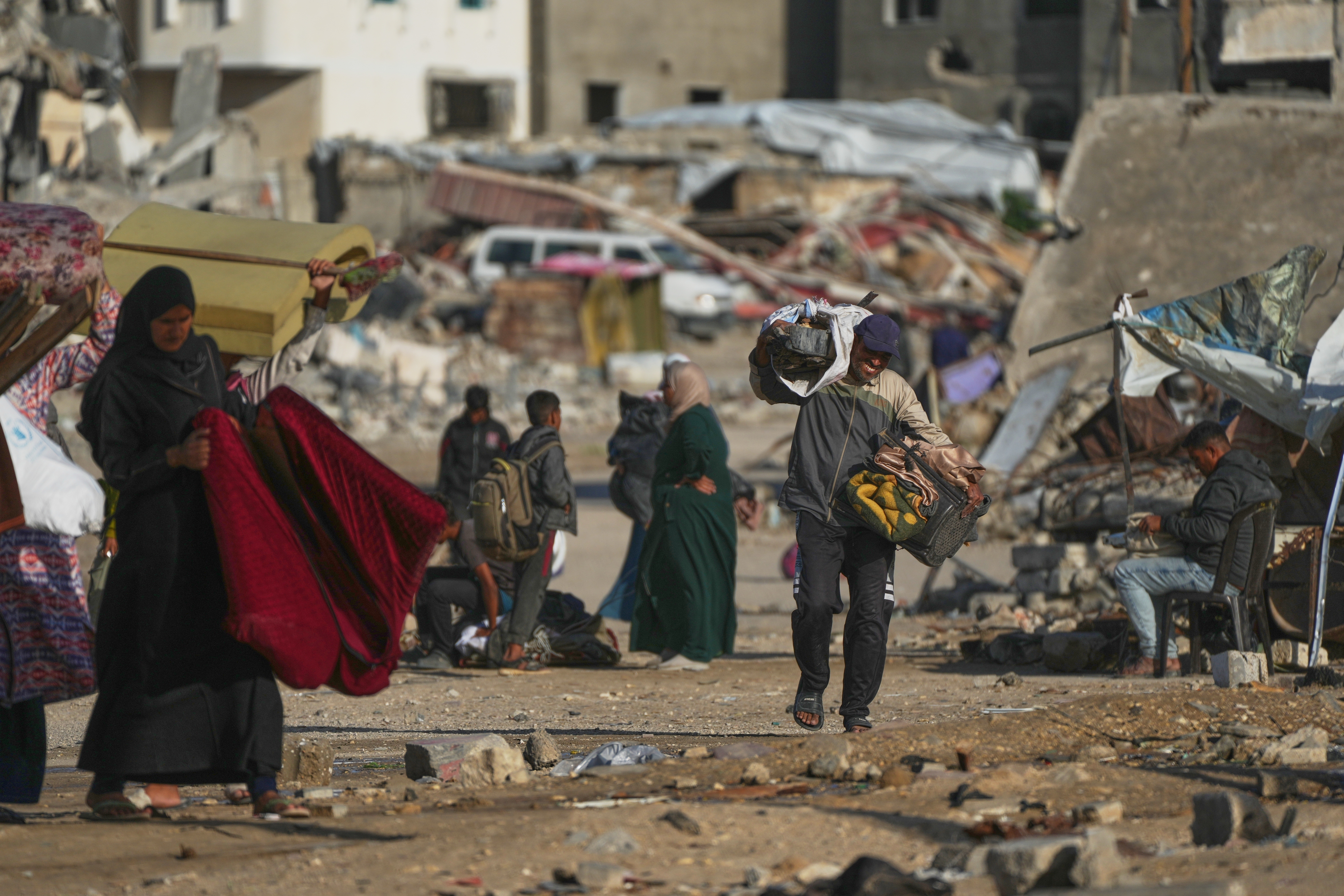 A Palestinian man carries bags of firewood after collecting it from the rubbish in Khan Younis, southern Gaza Strip, on Saturday.